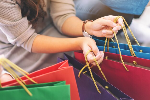 Closeup image of people holding shopping bags together