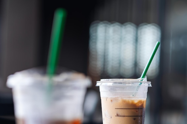 Photo closeup image of a plastic glass of iced coffee with straw