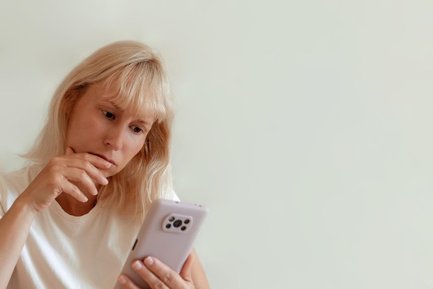 Closeup image of pretty woman sitting at cozy home interior and using modern smartphone device female hands typing text message via cellphone social networking concept