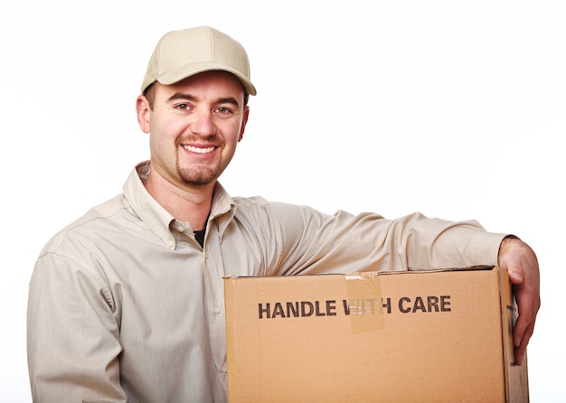 Closeup image of smiling young caucasian delivery man with parcel