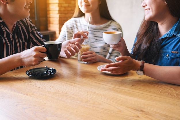 L'immagine del primo piano di tre persone si è divertita a parlare e a bere caffè insieme al bar