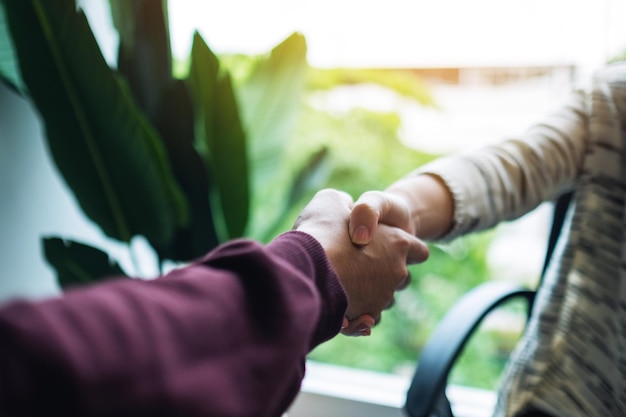 Immagine del primo piano di due persone che si stringono la mano