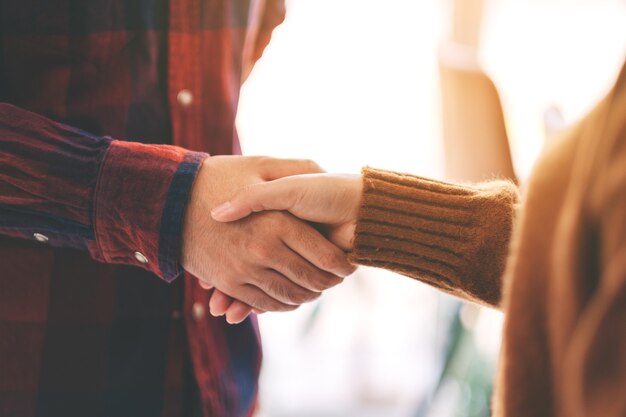 Immagine del primo piano di due persone che si stringono la mano