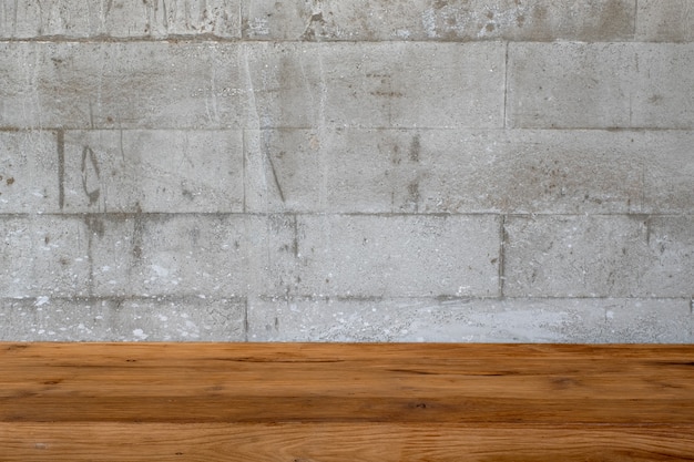 Closeup image of vintage wooden table with concrete wall texture and detail