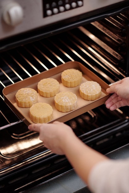 Immagine del primo piano della donna che cuoce i mooncakes tradizionale pasticceria vietnamita a casa