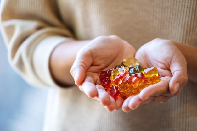 Closeup image of a woman holding colorful jelly gummy bears in hands