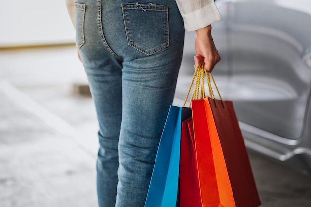 Foto immagine del primo piano di una donna che tiene le borse della spesa nel parcheggio del centro commerciale