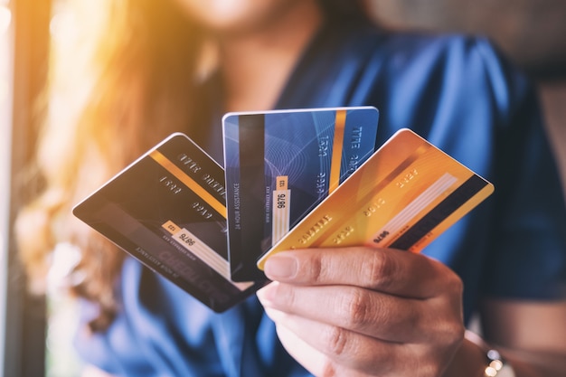 Photo closeup image of a woman holding and showing credit card