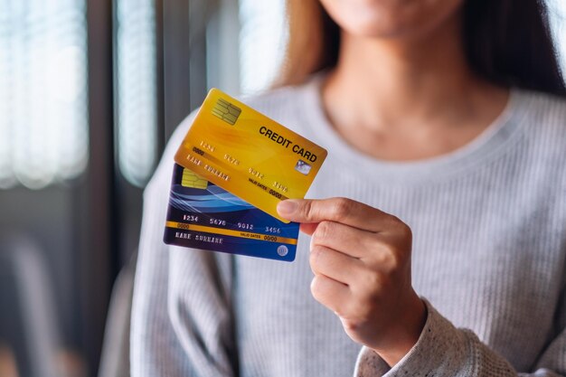 Foto immagine del primo piano di una donna che tiene e mostra le carte di credito