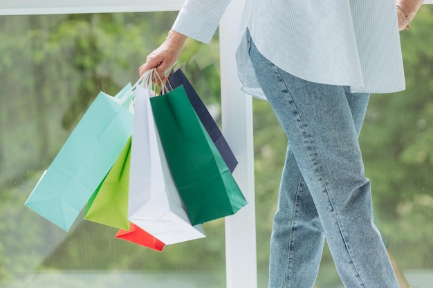 Closeup image of a woman holding and showing shopping bags online shopping concept