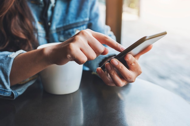 Photo closeup image of a woman holding and touching on mobile phone screen