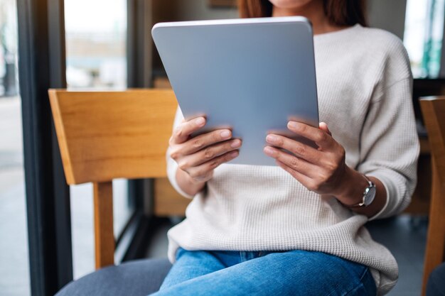 Photo closeup image of a woman holding and using digital tablet