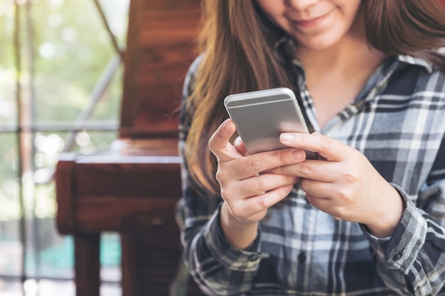 Foto immagine del primo piano di una donna che tiene, utilizzando e guardando smartphone