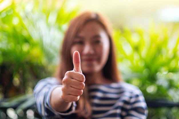 Foto immagine del primo piano di una donna che fa e mostra i pollici in su segno della mano