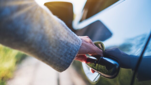 Closeup image of a woman opening the car doors