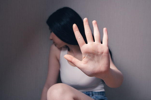 Closeup image of a woman outstretched hand and showing stop\
hand sign