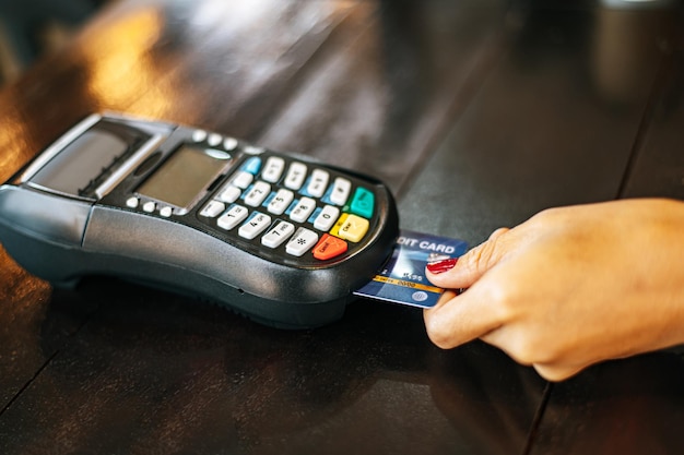 Closeup image of woman paying with credit card in cafe