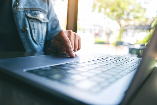 Closeup image of a woman's finger pressing on laptop computer touchpad