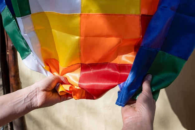 Photo closeup image of woman's hands clutching a silk wiphala flag