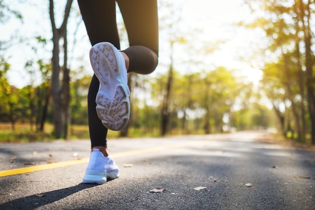 Immagine del primo piano delle gambe di una donna mentre fa jogging nel parco cittadino al mattino