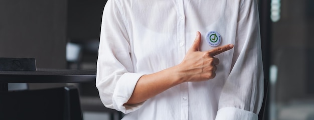 Closeup image of a woman showing Covid19 vaccinated sign brooch on shirt