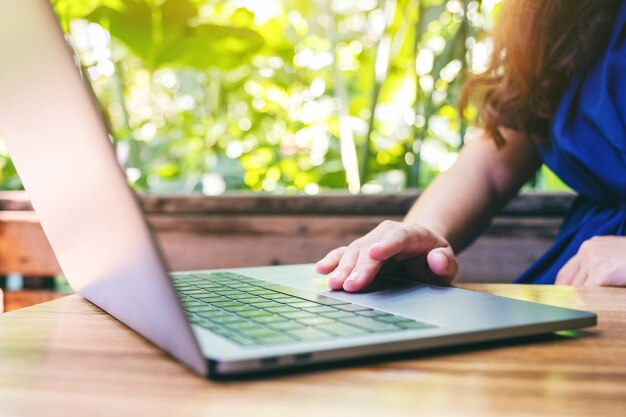 Closeup image of a woman using and touching on laptop touchpad