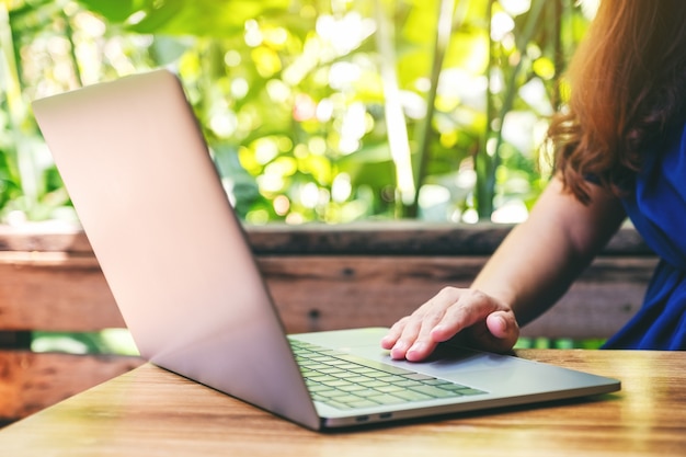 Closeup image of a woman using and touching on laptop touchpad