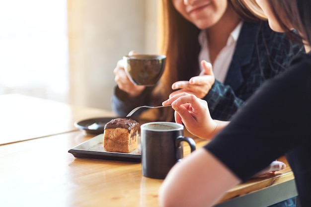 カフェで一緒にデザートを食べたり、コーヒーを飲んだりして楽しんだ女性のクローズアップ画像