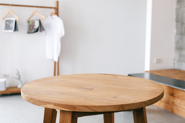 Photo closeup image of a wooden table and clothes rank in minimalist house