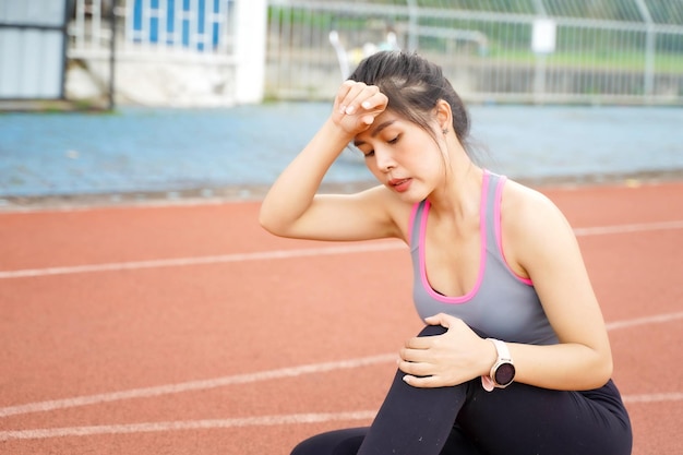 Крупный план молодой женщины с травмой колена после травмы во время тренировки