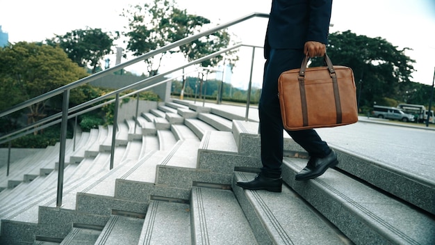 スマートなビジネスマンがバッグを持って足を歩いているクローズアップ画像 Exultant