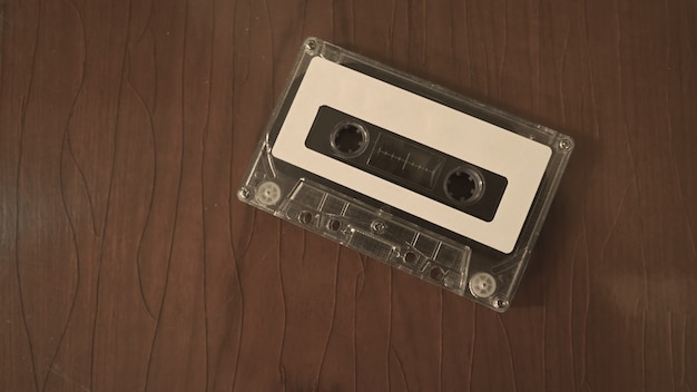 Closeup images of cassette tape on retro wood table represent nostalgia mood or moment to 80s