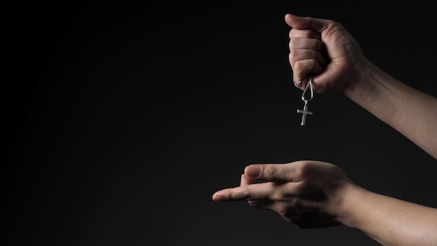 Closeup images of crucifix pendant necklace in man hand