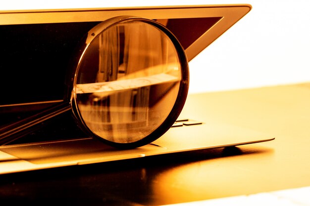 Closeup images of magnifying glass on laptop keyboard