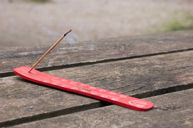 Closeup of incense holder red with burning incense on outdoor