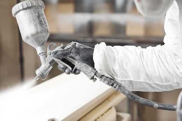 Closeup of industrial worker using paint gun or spray gun for applying paint Application of flame retardant ensuring fire protection airless spraying