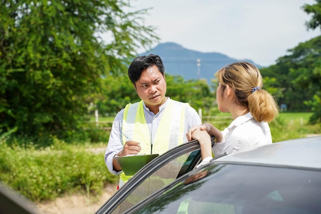 Closeup the insurance company officers ask the female driver about accident to write a report