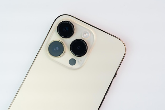 흰색 배경에 격리된 iPhone 14 Pro Gold의 근접 촬영 3개의 카메라가 선택적 초점 기능