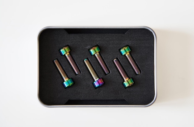 Closeup of isolated titanium m5 screws set with rainbow covering Lightweight alloy hardware with chameleon color finishing