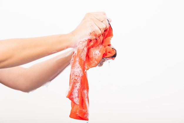 Closeup jonge Aziatische vrouw gebruikt handen wassen kleur kleding met wasmiddel hebben zeepbellenwater