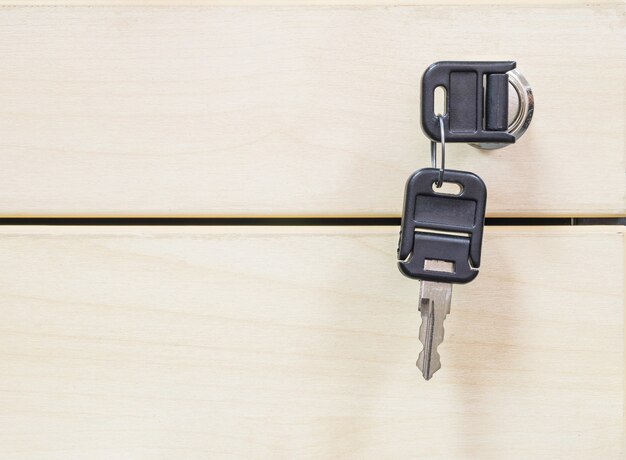 Closeup keys at the wooden drawer texture background