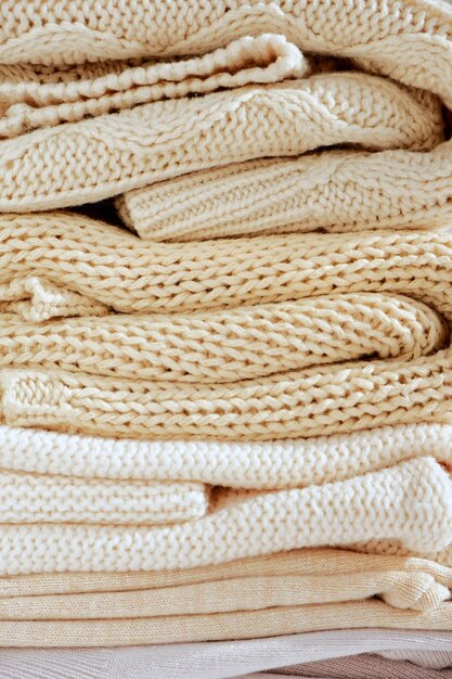 Photo closeup of knitted clothes in warm beige shades with a different pattern texture background