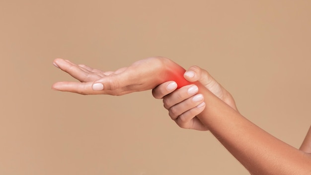 closeup of lady holding painful wrist touching inflamed red zone panorama copy space