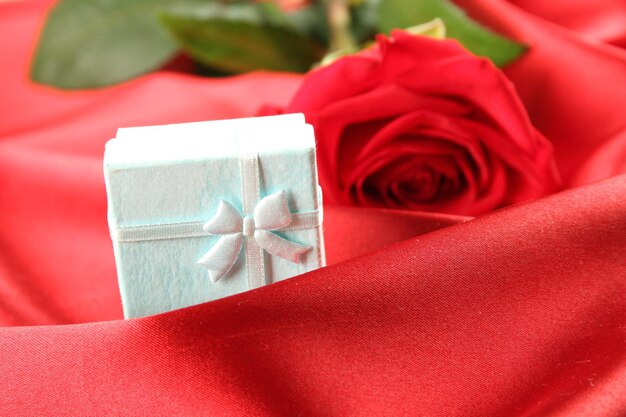 Closeup of a large Red rose on satin Background