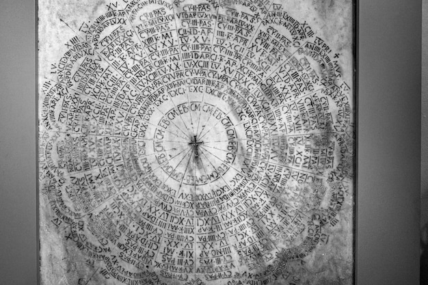 Closeup of a Latin liturgical calendar on a marble grave in Ravenna, Italy