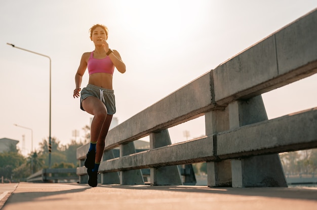 足のクローズアップ街で朝のトレーニングでジョギングしているアジアの女性健康に暮らす街