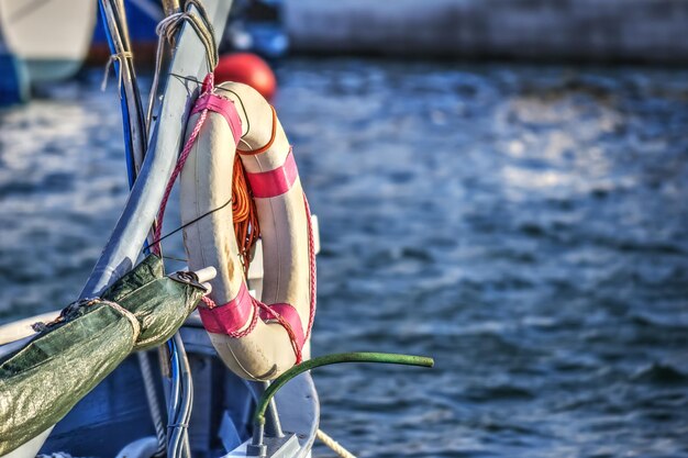 Foto primo piano di un salvagente su una barca di legno