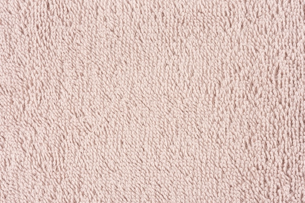 Closeup of a light pink towel. Textile details backdrop.