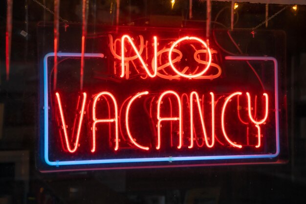 Closeup of the lighted signage saying NO VACANCY on the glass window