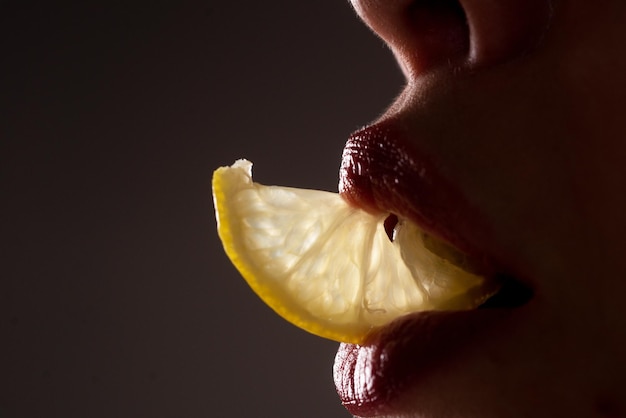 Фото Губы крупным планом с лимонами ломтик лимона во рту летний коктейль
